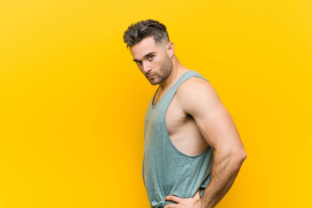Caucasian trainer man posing against a yellow background - Photo, Image