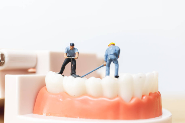 Μινιατούρα άτομα: εργαζόμενος ομάδα επισκευή ένα δόντι - Φωτογραφία, εικόνα