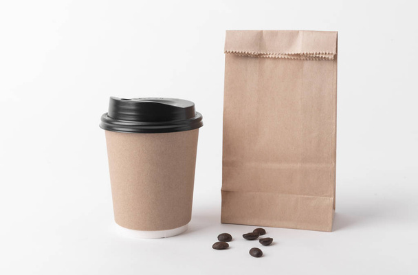 Порожній коричневий паперовий мішок та чашка кави для маскування шаблону логотипу реклами та брендингу
.  - Фото, зображення