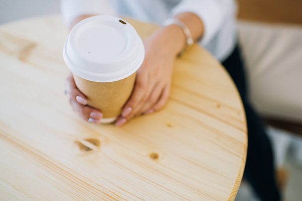 Female hands holding recyclable coffee cup. - Foto, imagen