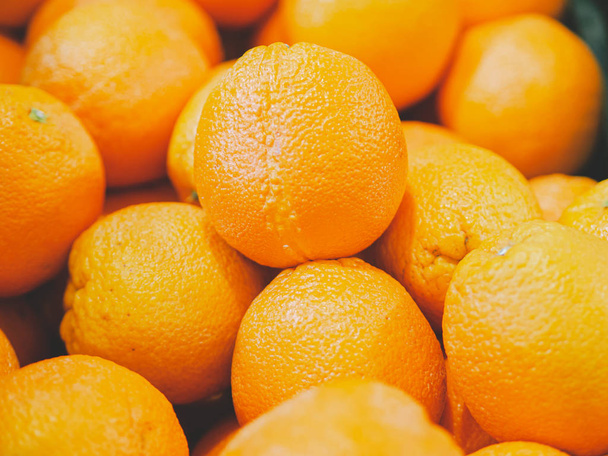Closeup bunch of fresh oranges in a box at the supermarket. Fruit textures for wallpaper. - Photo, image