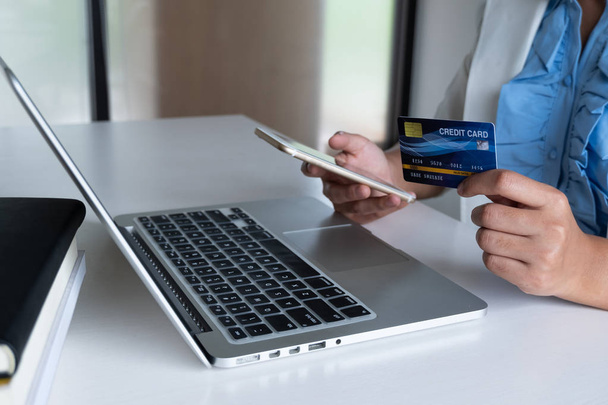 επιχείρηση γυναίκα cosumer χρησιμοποιούν πιστωτική κάρτα για online αγορές στο laptop και το τηλέφωνό της για online αγορές και να κάνει μια πληρωμή αγοράς στο διαδίκτυο - Φωτογραφία, εικόνα