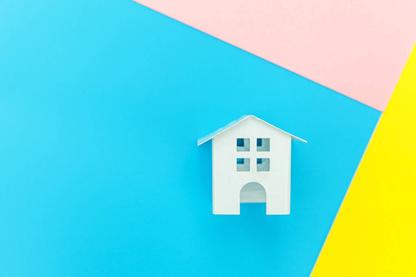 Casa giocattolo bianco in miniatura isolato su blu giallo rosa pastello colorato di tendenza sfondo geometrico
 - Foto, immagini