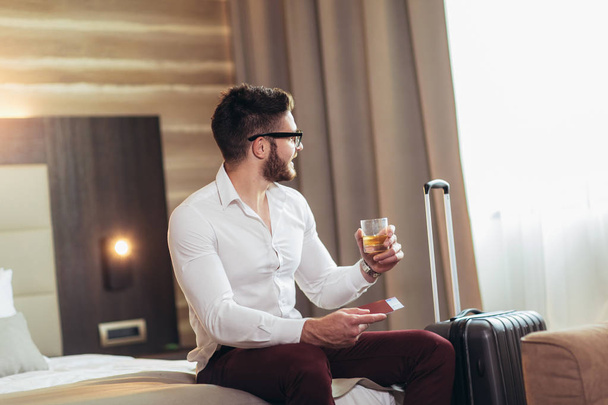Молодий чоловік бізнес-мандрівник в готельному номері
  - Фото, зображення