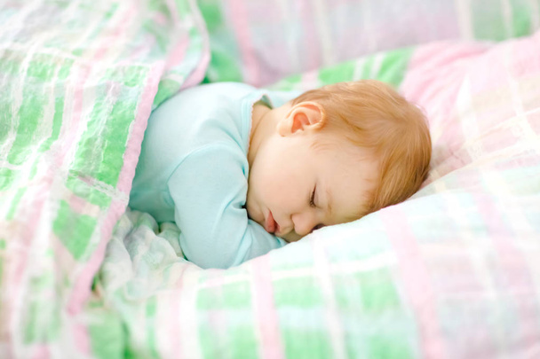 Adorable little baby girl sleeping in bed. Calm peaceful child dreaming during day sleep. Beautiful baby in parents bed. Sleeping together concept. - Zdjęcie, obraz
