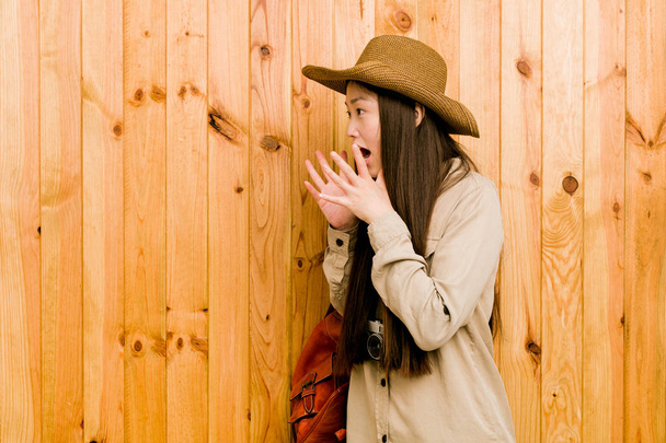Young chinese traveler woman shouts loud, keeps eyes opened and hands tense. - Foto, Bild