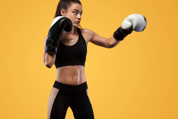 Sportsman, woman boxer fighting in gloves. on yellow background. Boxing and fitness concept. - Photo, Image