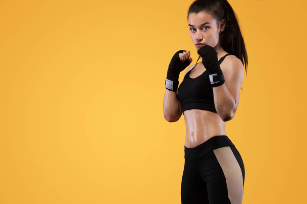 Sportsman, woman boxer fighting in gloves. on yellow background. Boxing and fitness concept. - Fotó, kép