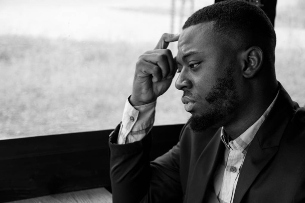 Portrait of young black man looks at window turns his head and looks at camera. - Φωτογραφία, εικόνα