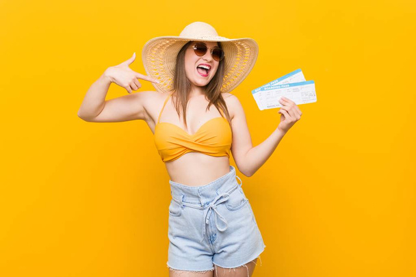 Joven mujer caucásica lista para ir a la playa con billetes de avión
 - Foto, imagen