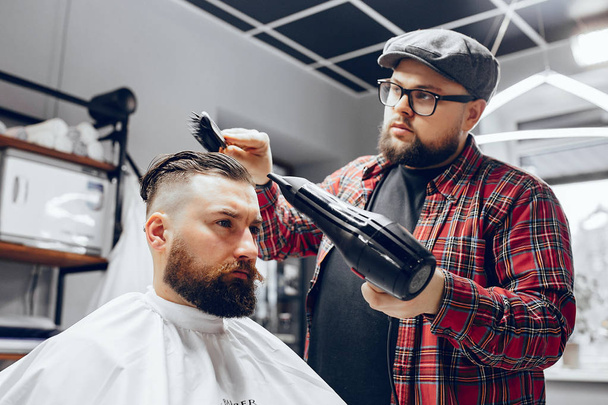 Stylish man sitting in a barbershop - Foto, imagen