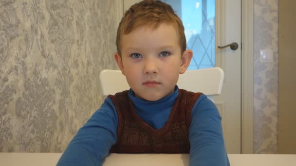 emotioneel vertelt het verhaal van een jongen aan tafel - Video