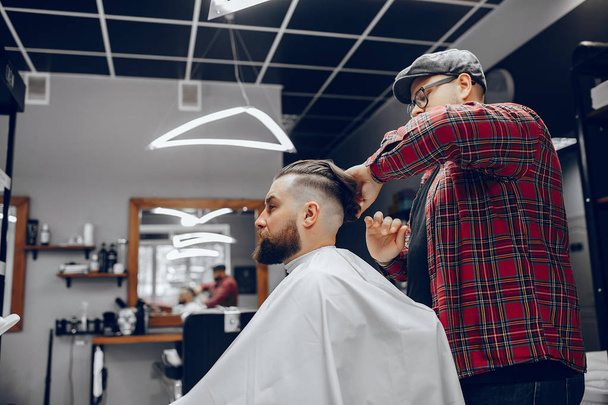 Stylish man sitting in a barbershop - Фото, изображение