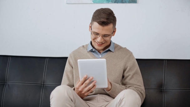 smiling man in glasses using digital tablet - 映像、動画