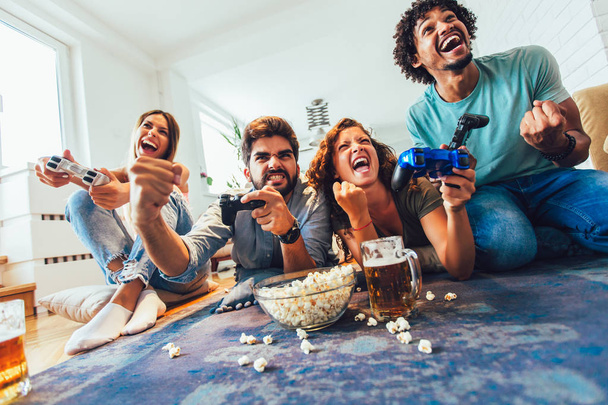 Group of friends play video games together at home, having fun. - Фото, зображення