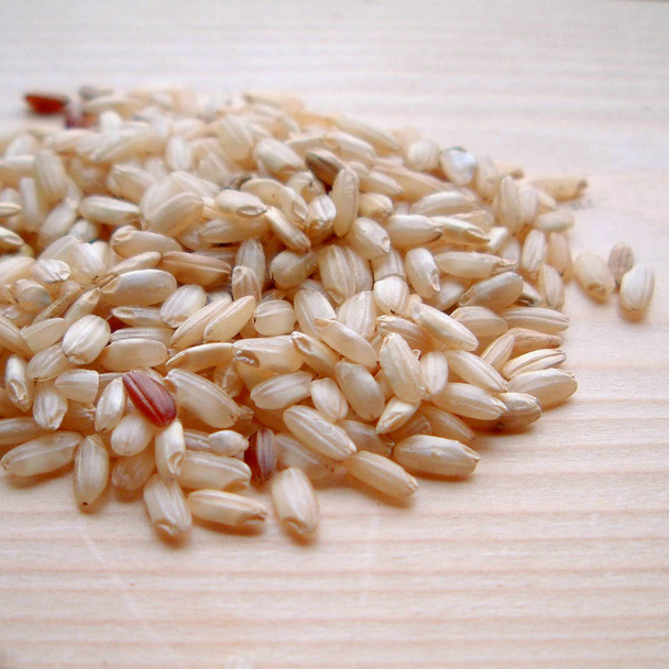 Bruine rijst op een houten tafel - Foto, afbeelding