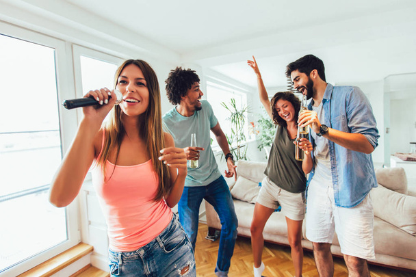 Grupo de amigos jogando karaoke em casa. Conceito sobre friendsh
 - Foto, Imagem