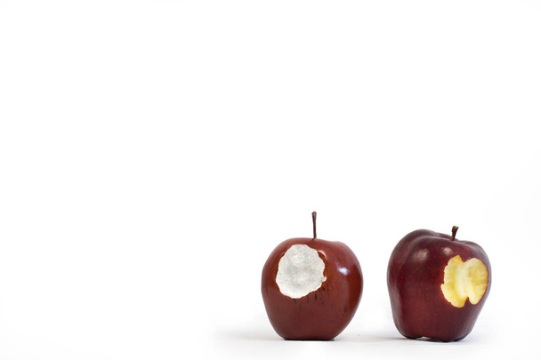 Mela finta di polistirolo accanto a una vera mela. Sfondo bianco con spazio di copia
.  - Foto, immagini
