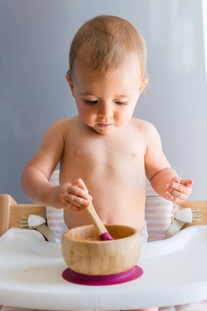 Baby meisje ongeveer een jaar eten van een wortel met baby LED-speen methode - Foto, afbeelding
