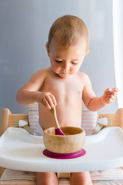 Bebé niña alrededor de un año comer una zanahoria con el bebé llevó método de destete
 - Foto, Imagen