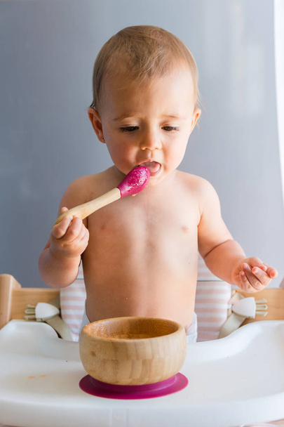 Baby Mädchen etwa ein Jahr essen eine Karotte mit Baby led Entwöhnungsmethode - Foto, Bild