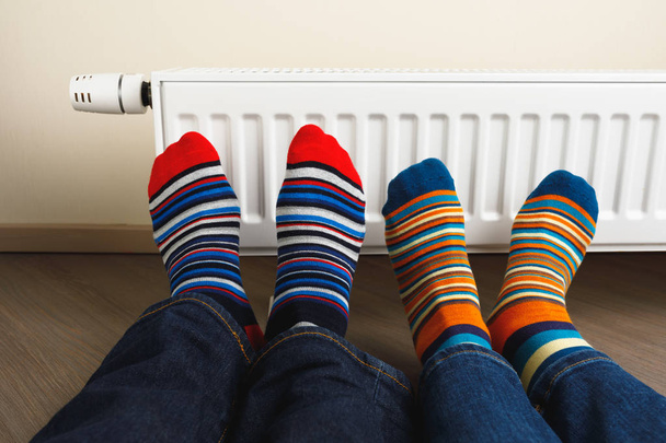 lábak színes zoknit a fűtőtest előtt - Fotó, kép