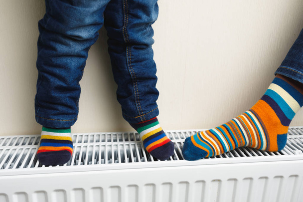 pieds enfant avec chaussettes colorées sur radiateur
 - Photo, image