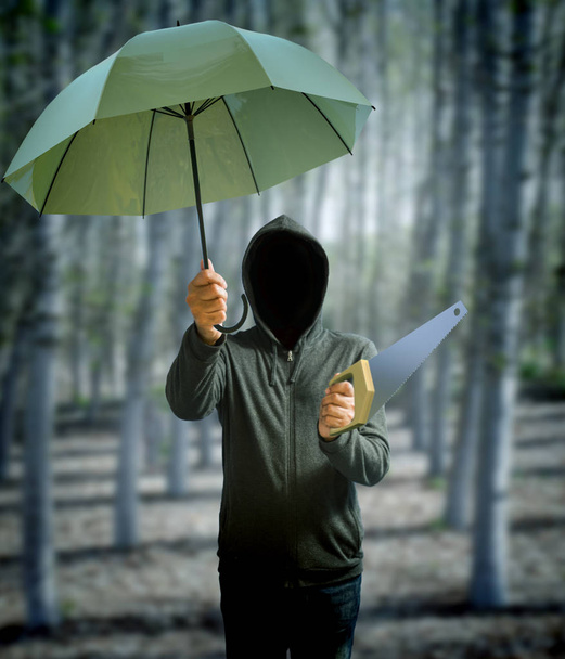 Hooded mysterious man with umbrella and carpenter greenhouse - 写真・画像