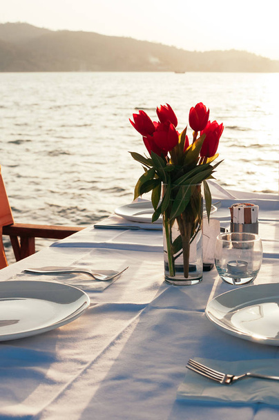 tavola apparecchiata con fiori al ristorante sulla spiaggia
 - Foto, immagini