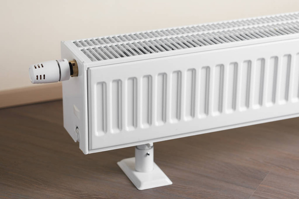 radiatore di riscaldamento con manopola termostatica in soggiorno
 - Foto, immagini