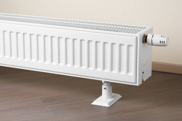 radiador de calefacción con mando termostático en la sala de estar
 - Foto, imagen