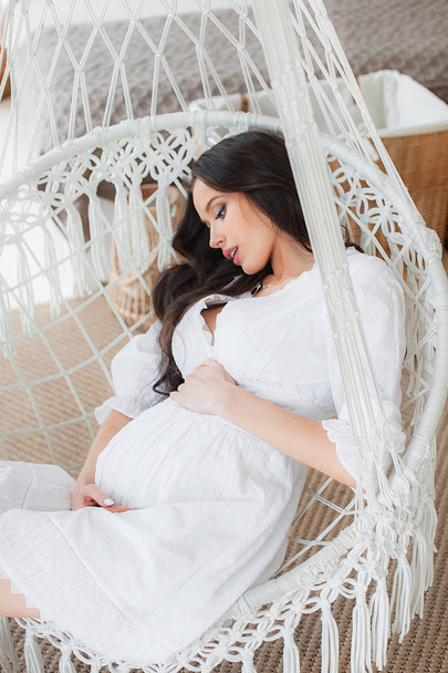 Young beautiful pregnant woman in white dress - 写真・画像