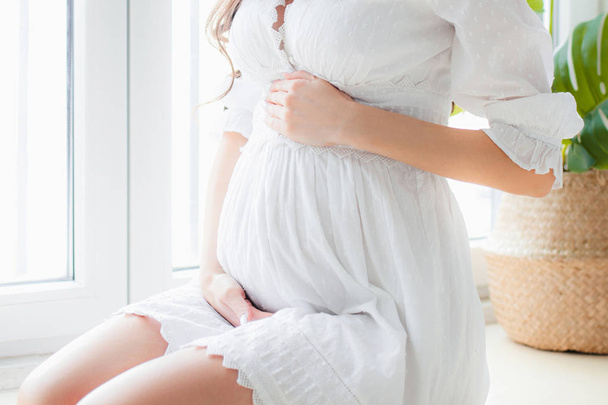 Młoda piękna kobieta w ciąży w białej sukni - Zdjęcie, obraz