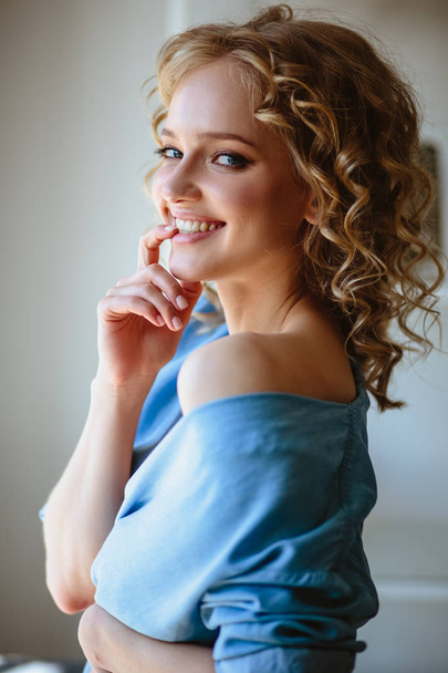 Close up portrait of blonde charming young woman with curly hair and natural makeup. Sunny morning, spa and care - Zdjęcie, obraz