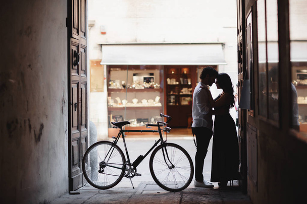 Fotosession des Liebespaares. Ein Mann und eine Frau laufen mit einem grünen Retro-Fahrrad durch die Altstadt - Foto, Bild