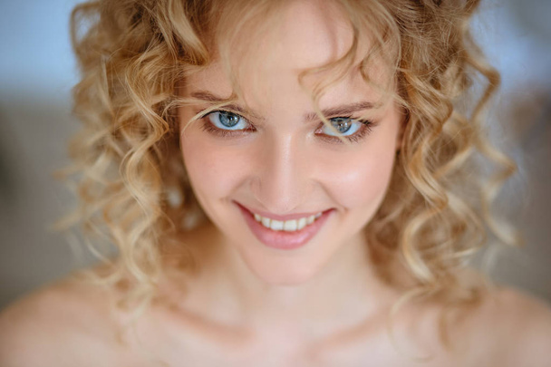Close up portrait of blonde charming young woman with curly hair and natural makeup. Sunny morning, spa and care - Valokuva, kuva