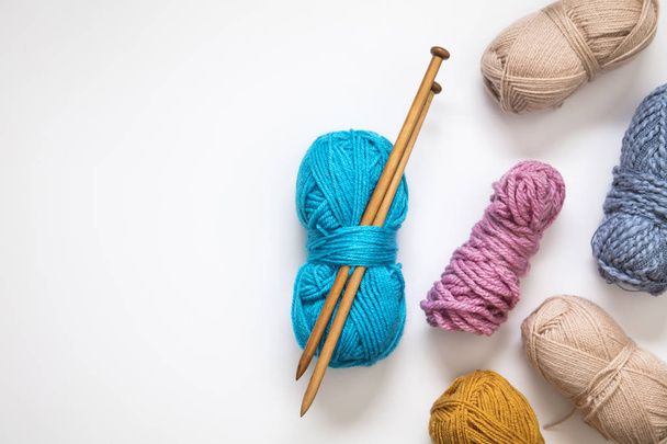 Knitting background. Balls of wool and knitting needles on a pla - Valokuva, kuva