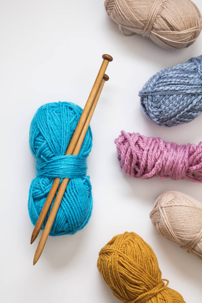 Knitting background. Balls of wool and knitting needles on a pla - 写真・画像