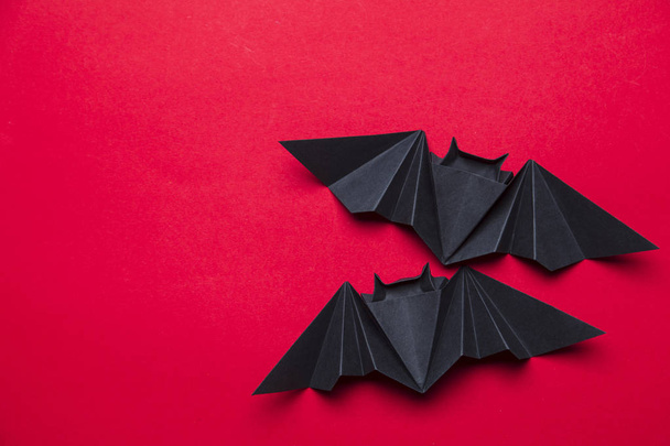 Murciélagos de Halloween hechos de papel sobre un fondo rojo
 - Foto, imagen