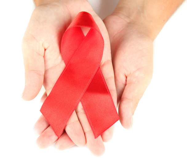 AIDS ribbon in hands isolated on white - 写真・画像