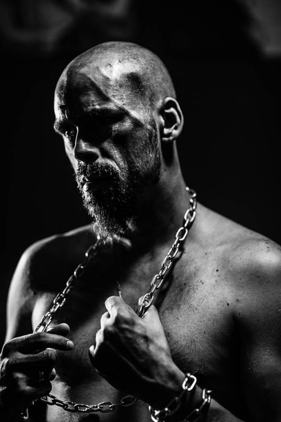black and white portrait of a brutal man tearing the chain  - 写真・画像
