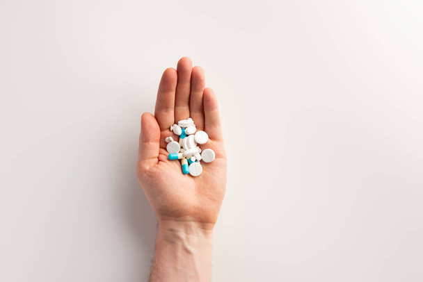Pills in hand, on white background. Flat lay. - Фото, зображення