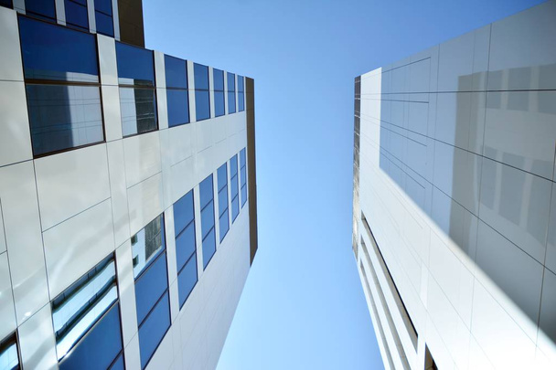 Nuevo edificio de oficinas en el centro de negocios. Pared de acero y vidrio con cielo azul. Arquitectura corporativa moderna - concepto de negocio y éxito
. - Foto, Imagen