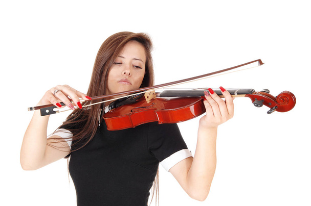 Μια νεαρή γυναίκα που στέκεται στο κοντινό παιχνίδι του βιολί - Φωτογραφία, εικόνα