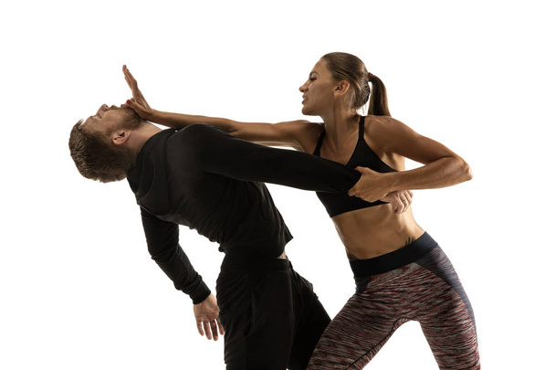 Man and woman fighting in studio, womens self-defense concept - Photo, image