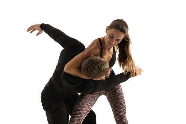 Man and woman fighting in studio, womens self-defense concept - 写真・画像