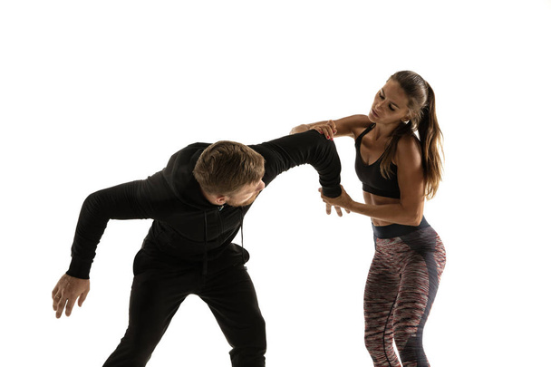 Man and woman fighting in studio, womens self-defense concept - Foto, afbeelding