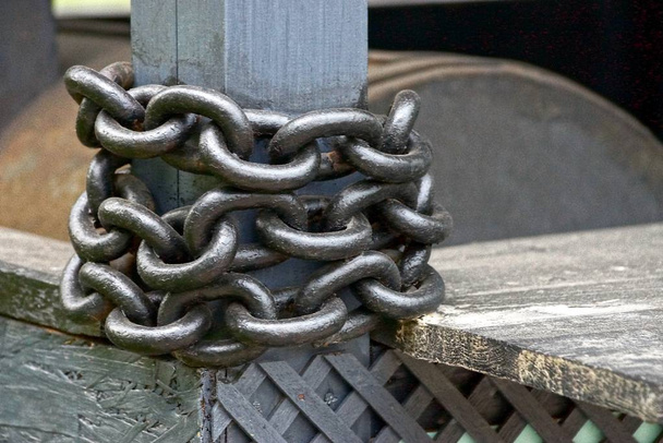 cadena de acero gris en el tubo de barrera en la valla
 - Foto, Imagen