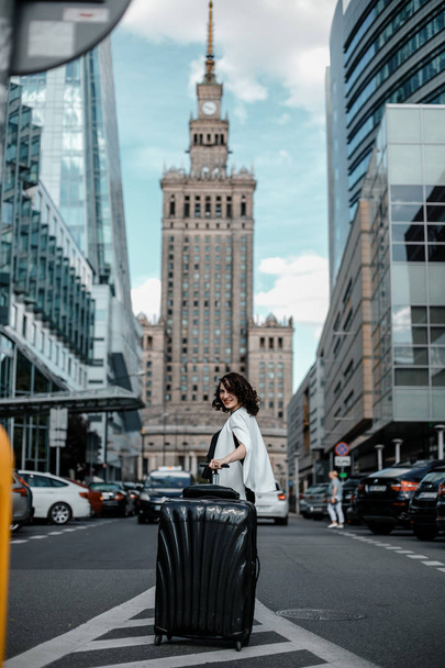 business travel business woman. Stylish girl with a suitcase in the big city. Business Vacation. Business trip. Warsaw - Photo, Image
