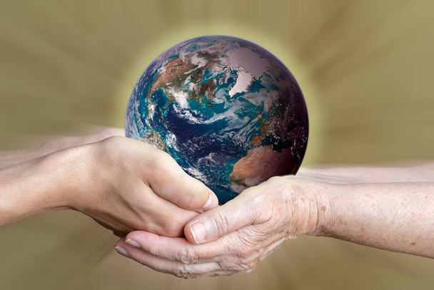 Stara i młoda osoba ręce trzyma planetę ziemię, koncepcja jedności. elementy tego zdjęcia dostarczone przez NASA - Zdjęcie, obraz